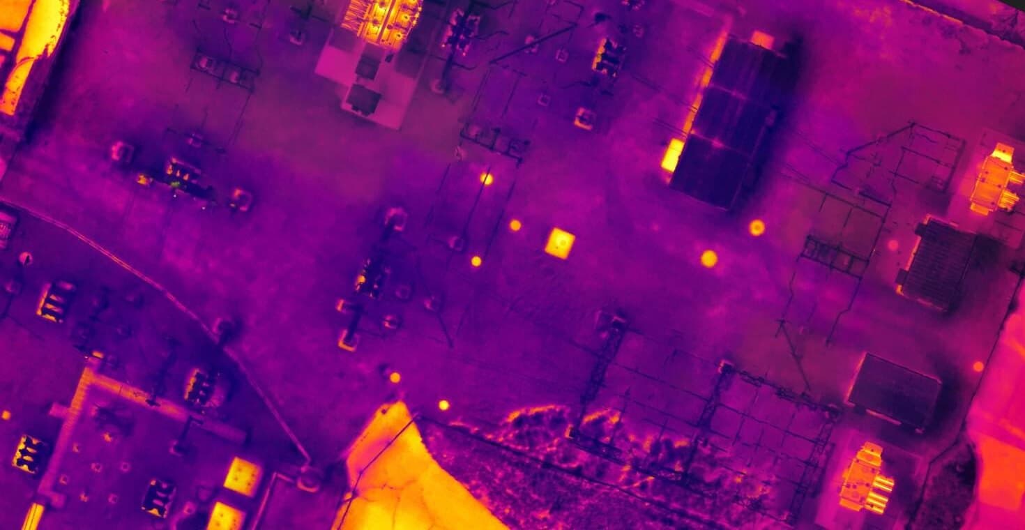 Radiometric thermal orthomosaic of an industrial rooftop with hot equipment showing bright against the cooler roof